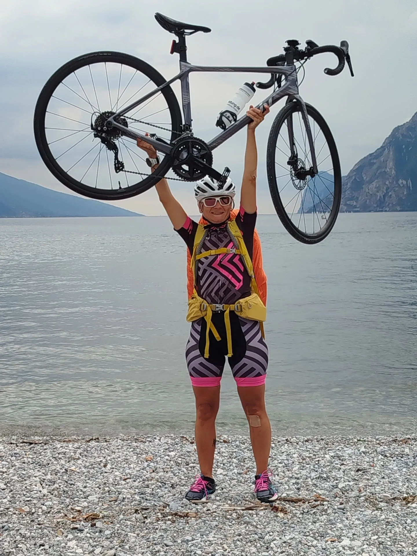Edith am Gardasee, das Rennrad über dem Kopf