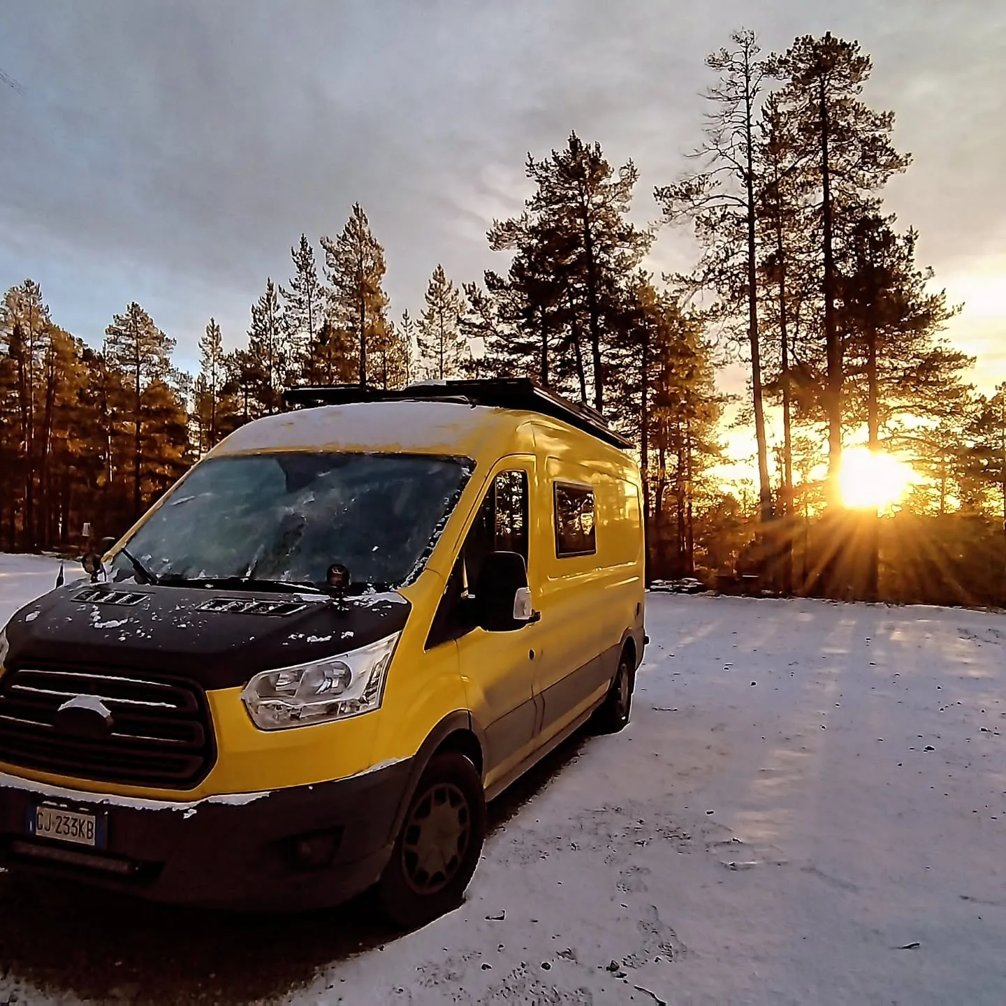 Der Van im ersten Schnee bei Sonnenaufgang am Wanderparkplatz