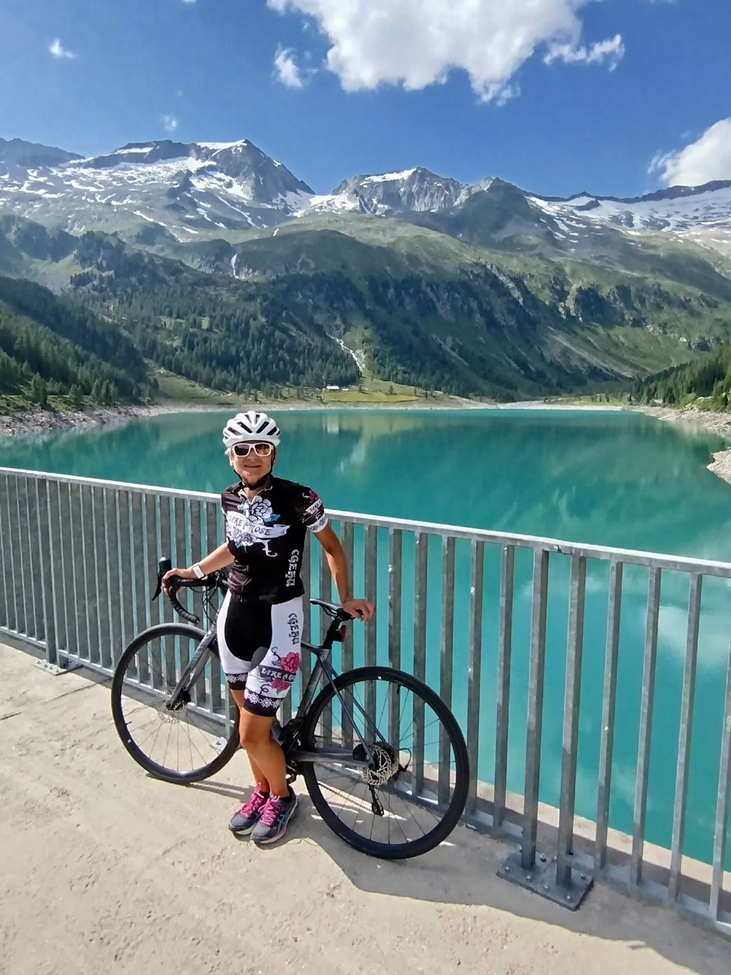 Edith mit dem Rennrad an einem türkisen Stausee