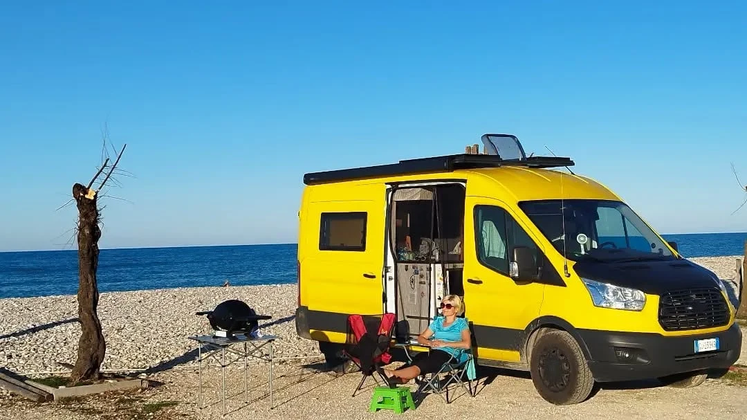 Unser Van am Strand an der Adria, wir beide in der Sonne