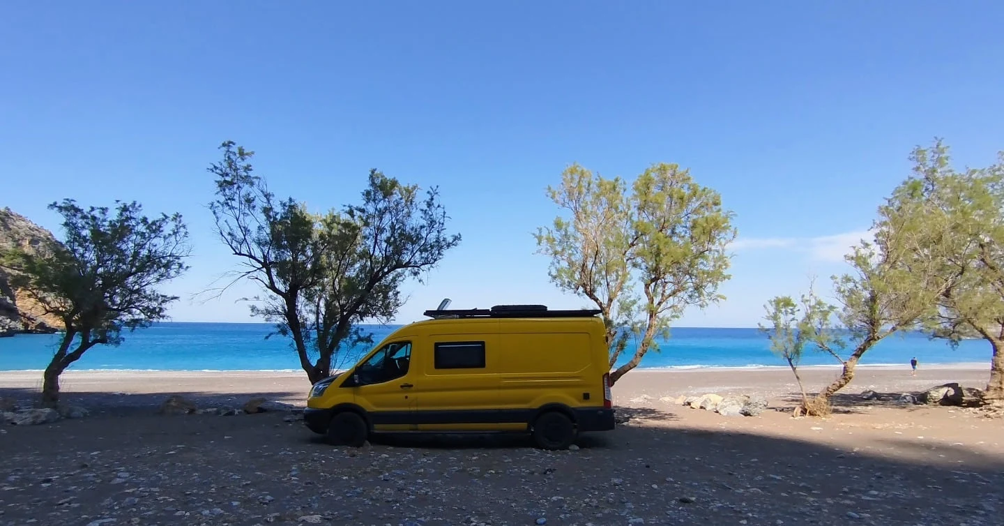 Der Van zwischen Bäumen am Hiliadou Beach