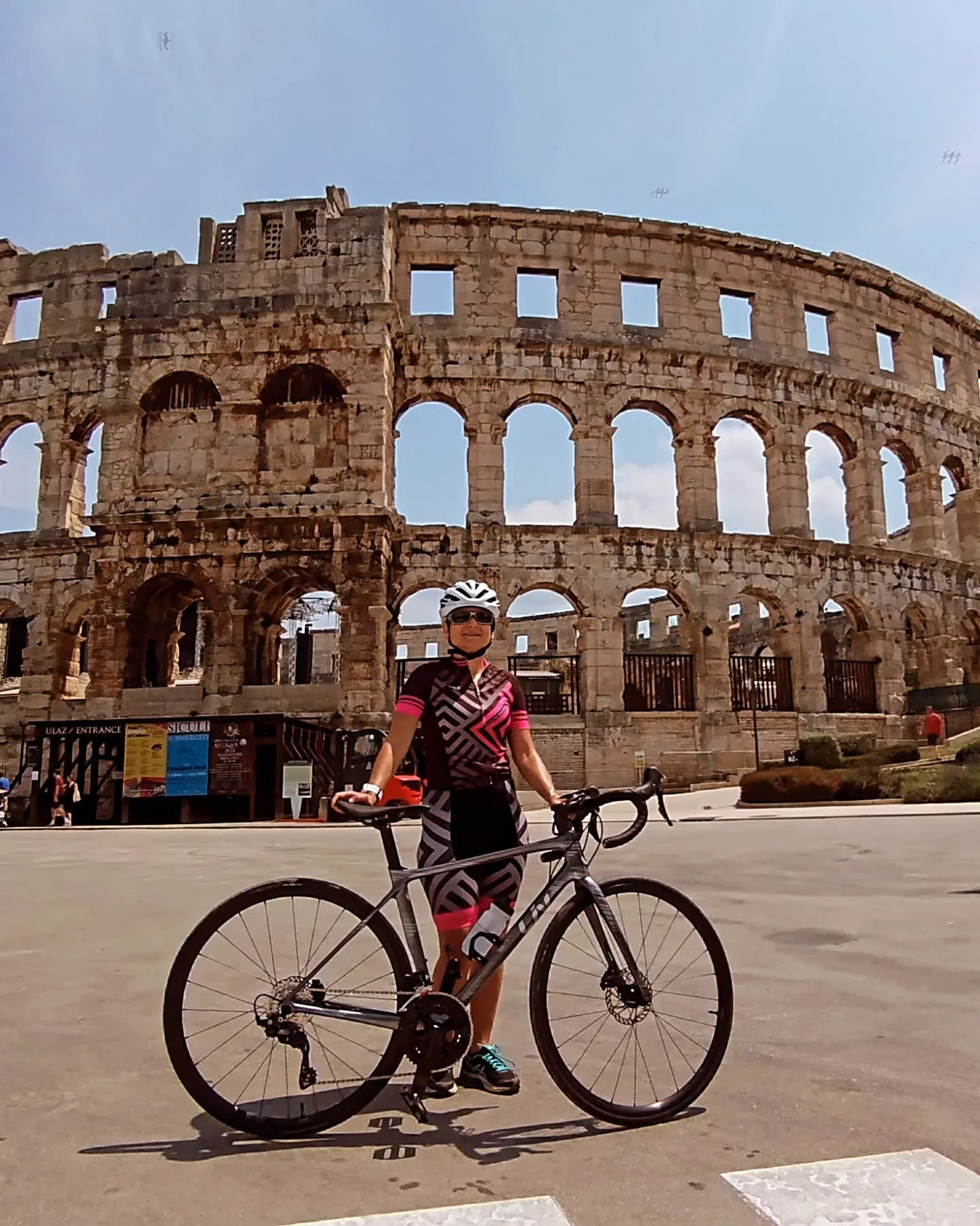Edith mit dem Rennrad vor der Arena von Pula