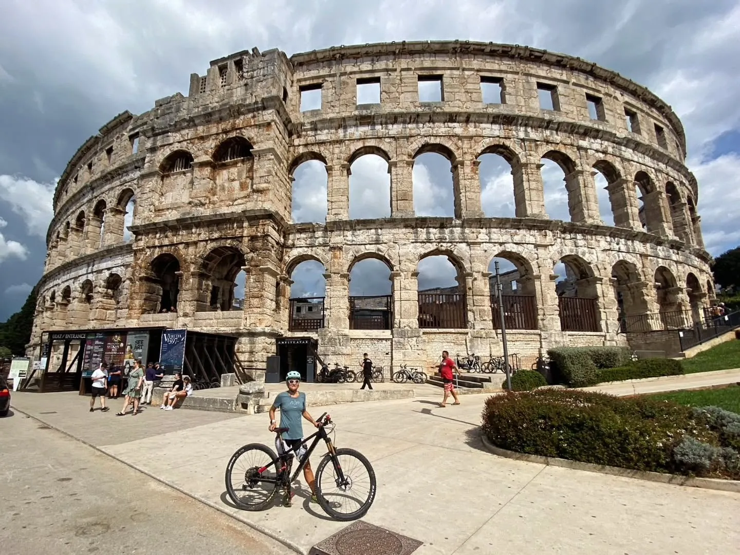 Mit dem Mountainbike vor der Arena von Pula
