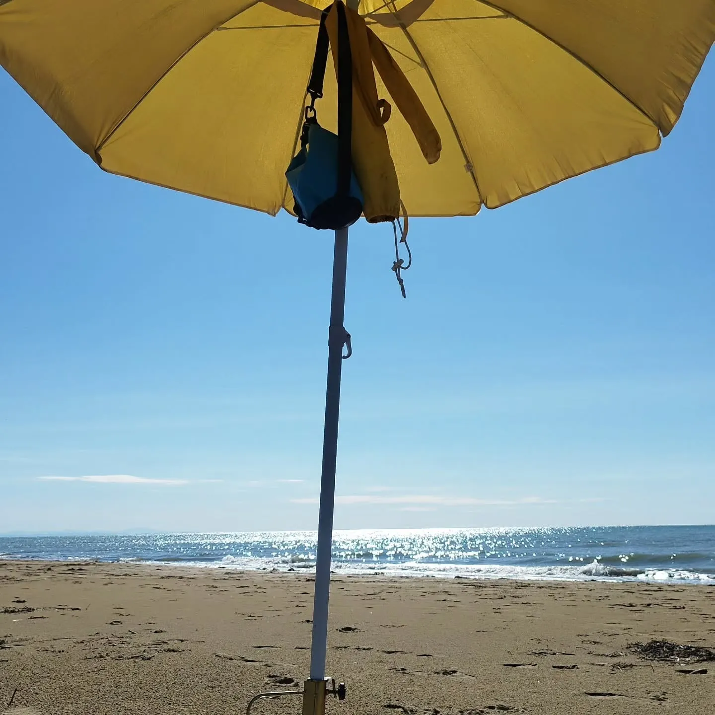Gelber Sonnenschirm am leeren Strand
