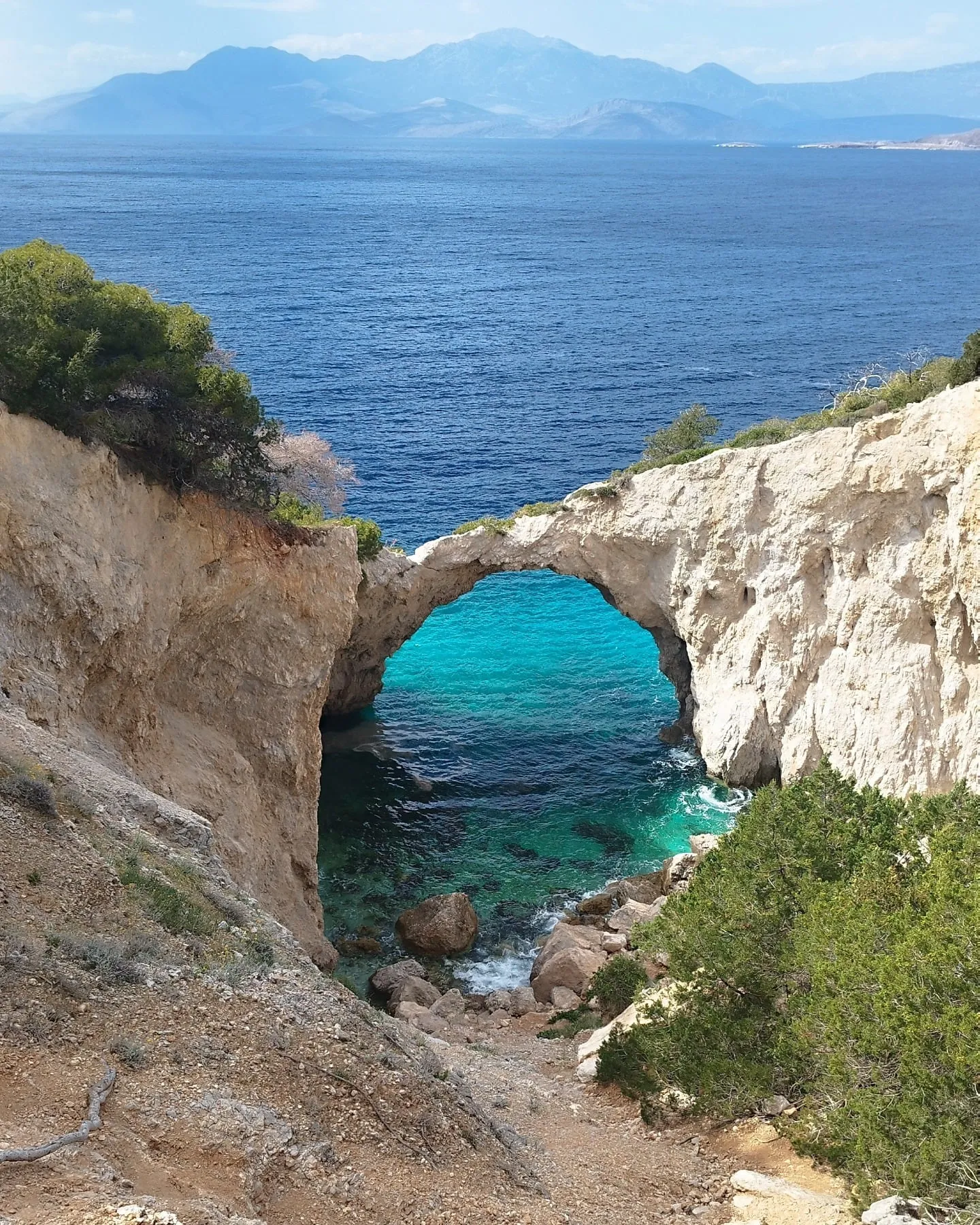 Felsbogen über einer türkisen Bucht