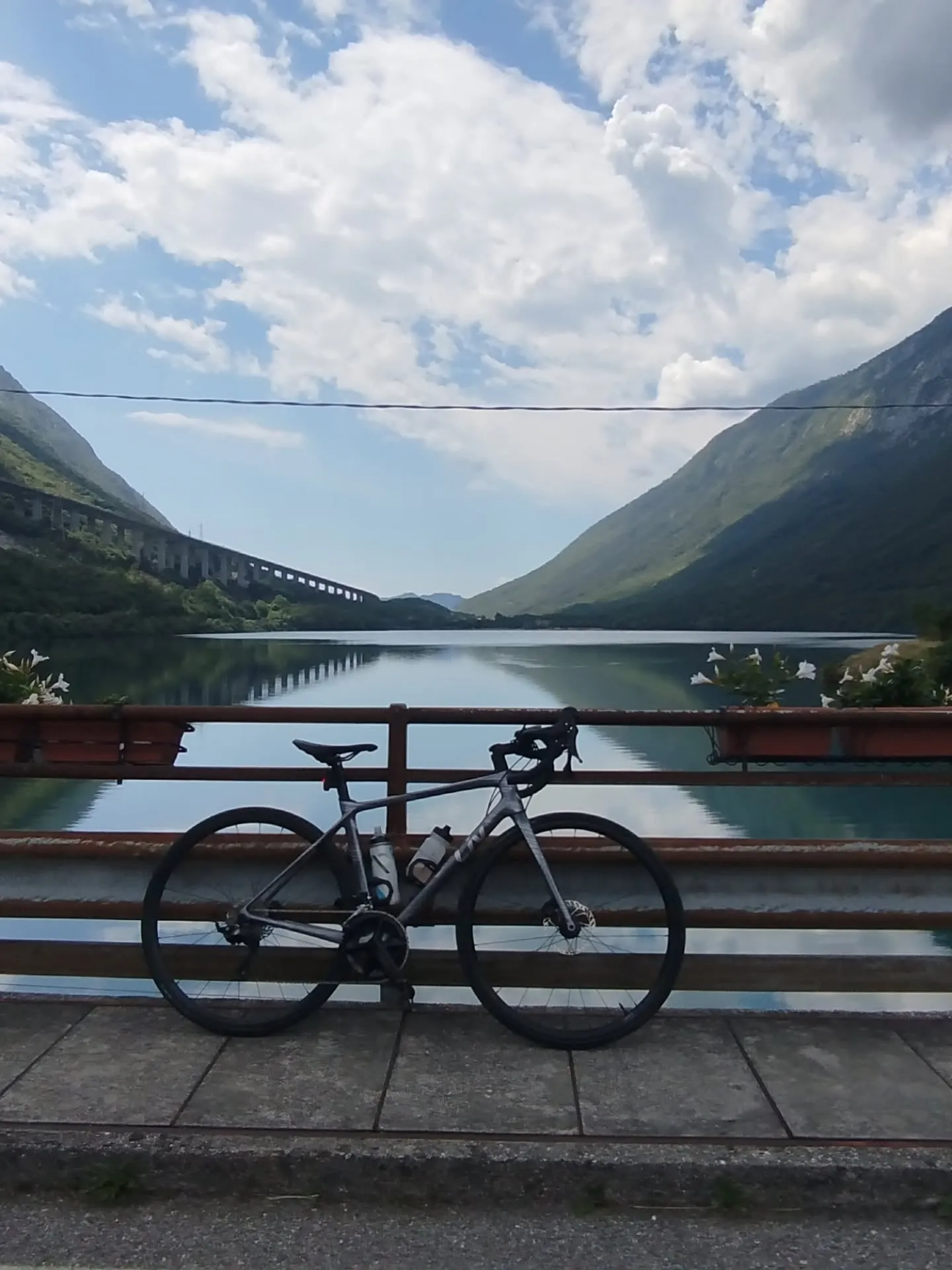 Rennrad am Geländer vor einem Bergsee