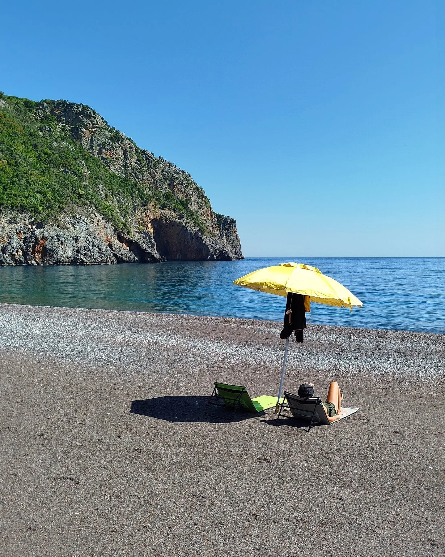Gelber Sonnenschirm am Kieselstrand