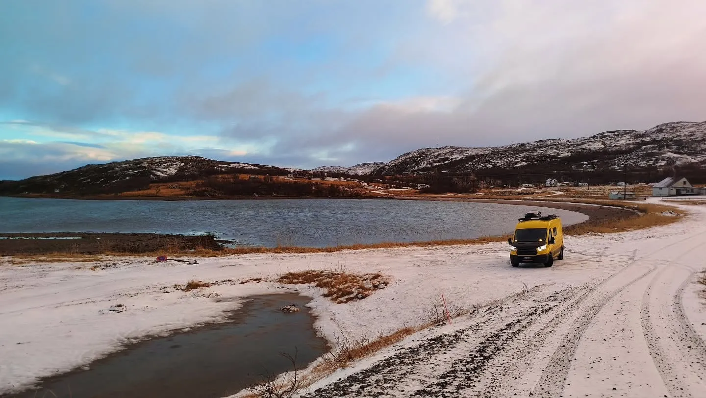 Weißer Sandstrand am Varangerfjord mit Schnee
