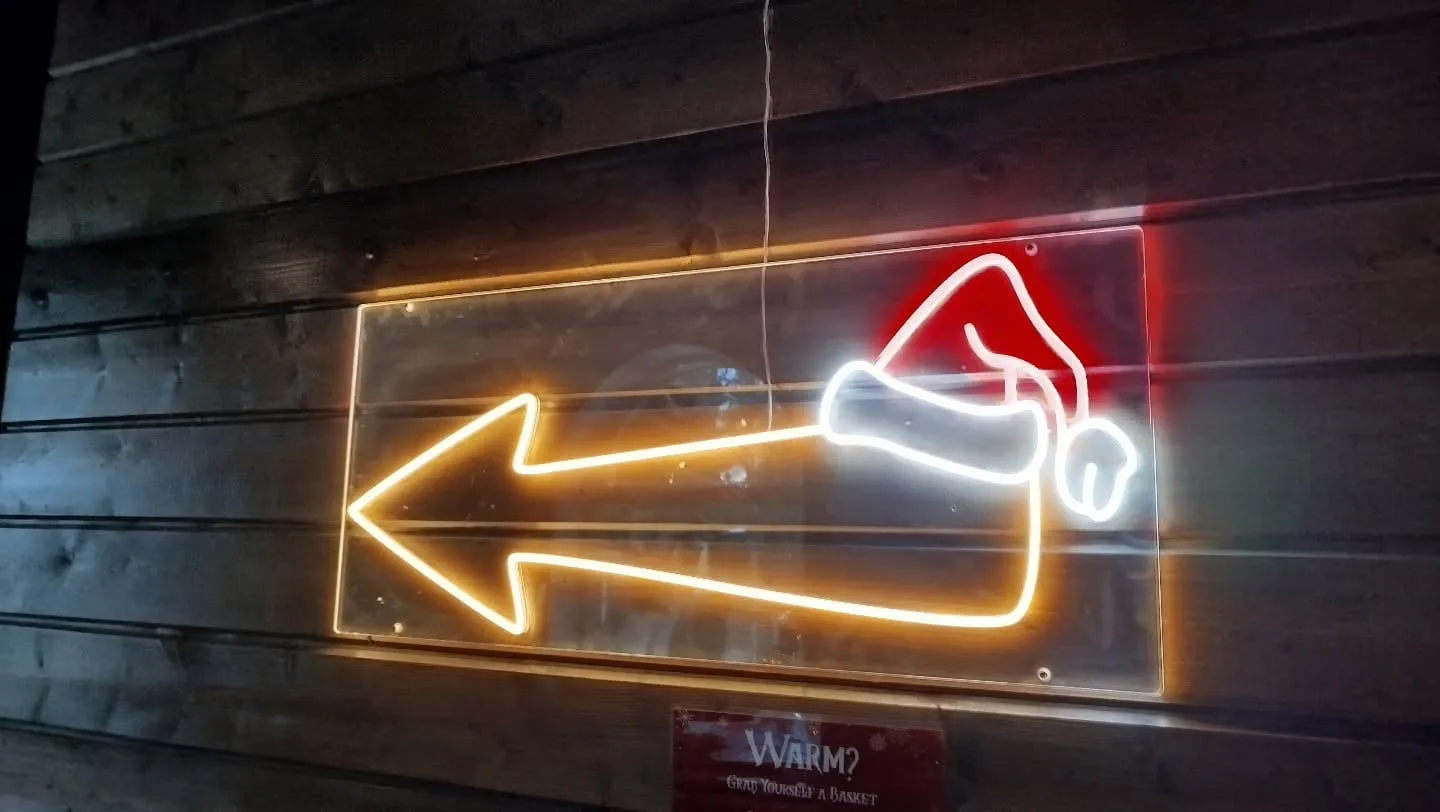 Neon-Wegweiser mit Weihnachtsmütze