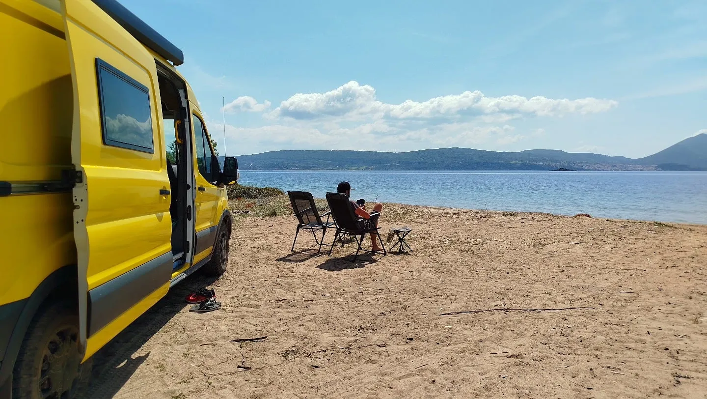 Campingstühle am Strand neben dem Van