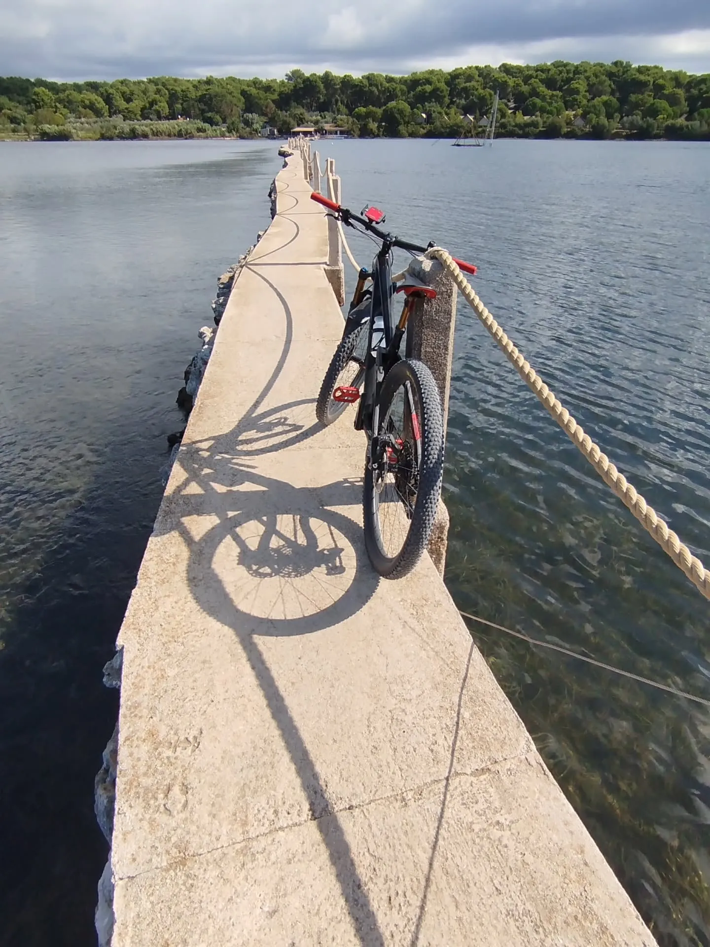Das Mountainbike auf einem schmalen Steg im Meer