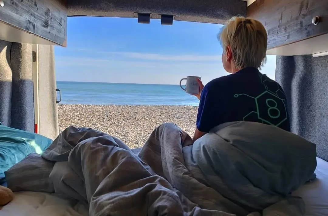 Edith mit Kaffee in der offenen Schiebetür, Meerblick