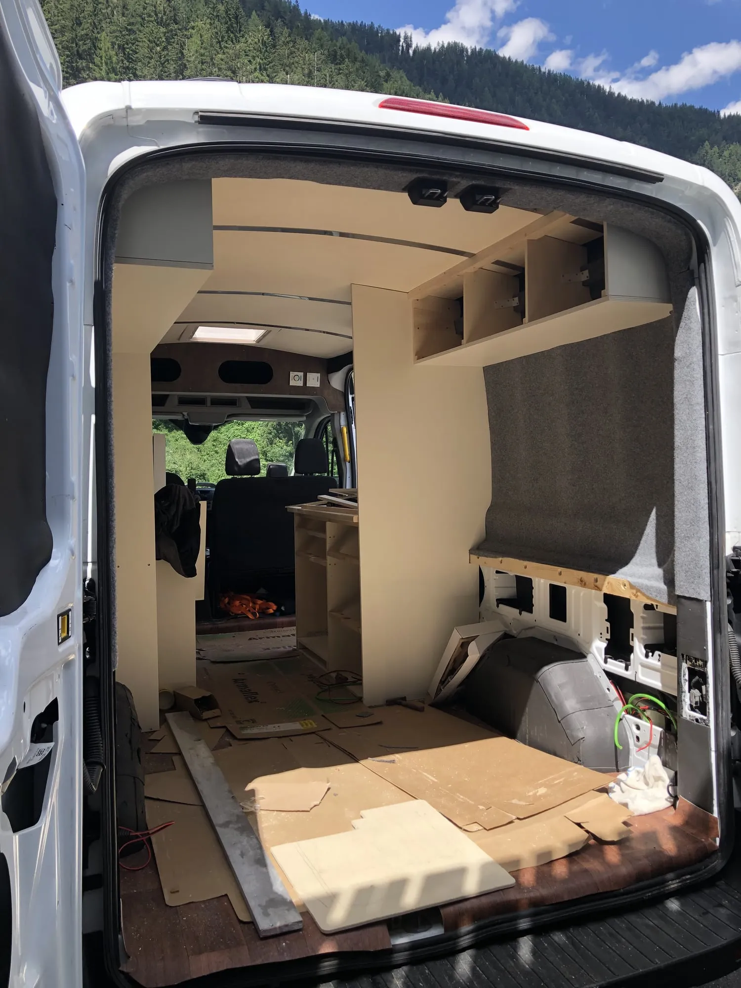 Blick durch die Hecktüren in den fast fertigen Ausbau mit Regalen und Holzboden